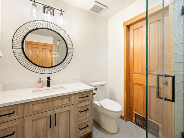 Full bathroom featuring vanity, tile patterned flooring, and a tile shower