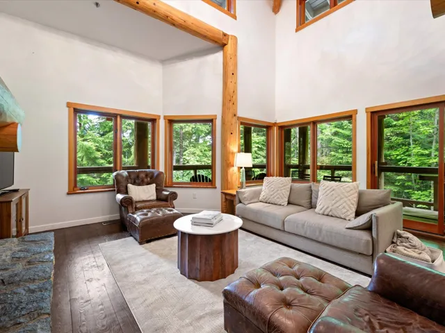 Living area with healthy amount of natural light, a high ceiling, and wood-type flooring