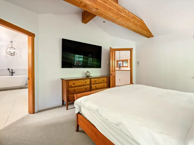 Bedroom with light carpet and a chandelier