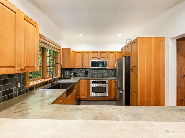 Kitchen featuring appliances with stainless steel finishes, tasteful backsplash, recessed lighting, and brown cabinets