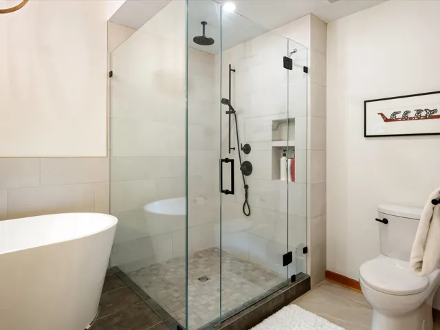 Bathroom featuring a shower stall, a freestanding bath, and tile patterned flooring