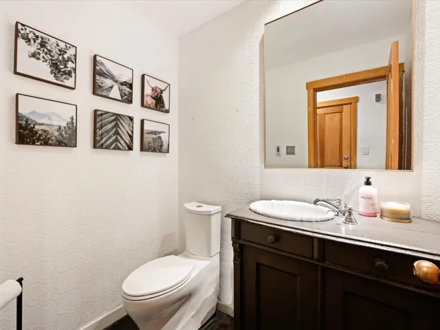 Half bathroom featuring vanity and a textured wall
