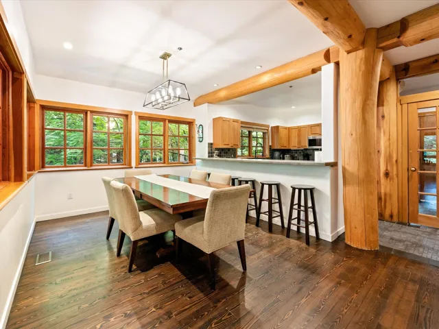 Dining space featuring dark wood-type flooring, recessed lighting, beamed ceiling, and a chandelier