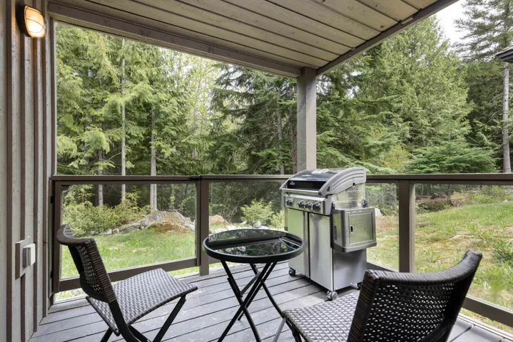 Deck featuring area for grilling and a wooded view
