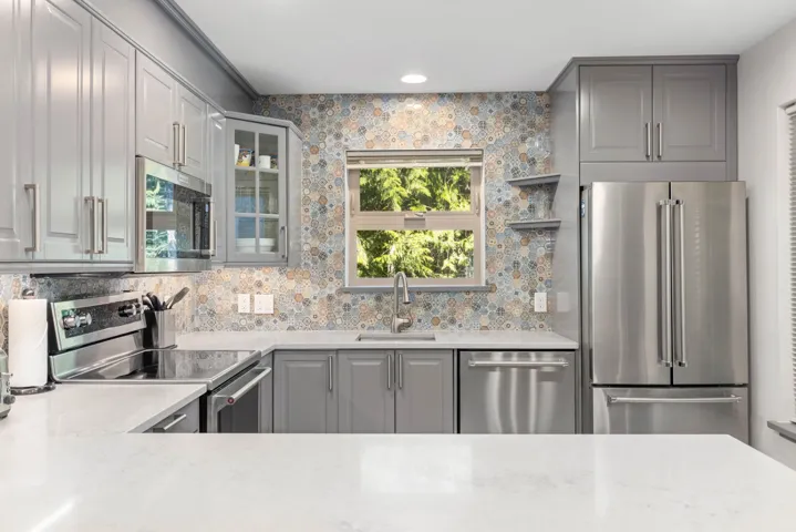 Kitchen featuring stainless steel appliances, a sink, gray cabinets, light countertops, and recessed lighting