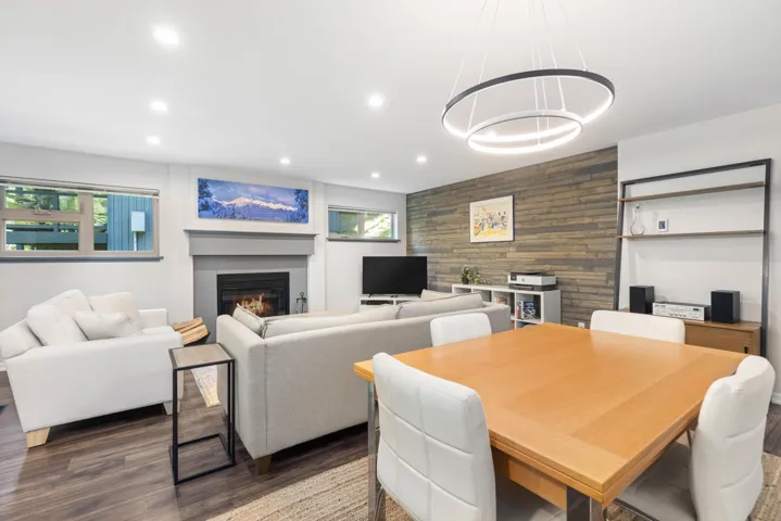 Dining room featuring a glass covered fireplace, recessed lighting, wood finished floors, wood walls, and an accent wall
