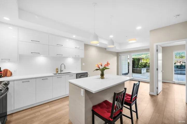 Kitchen featuring white cabinetry, modern cabinets, a kitchen bar, and recessed lighting