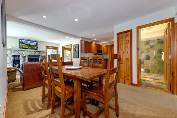 Dining room featuring light colored carpet, recessed lighting, and a fireplace