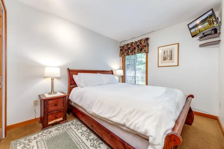 Bedroom with light colored carpet and baseboards