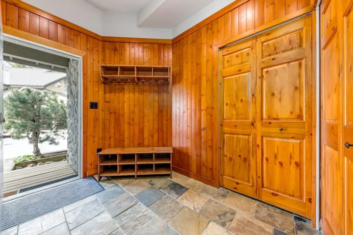 Mudroom with stone finish flooring and wooden walls