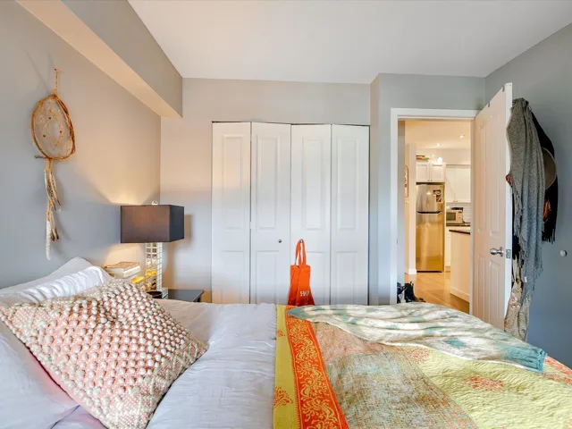 Bedroom featuring a closet, wood finished floors, and freestanding refrigerator