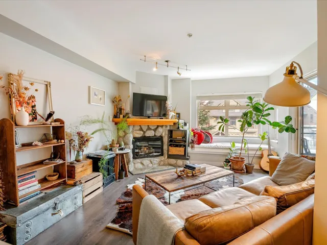 Living room with a fireplace, track lighting, and wood finished floors