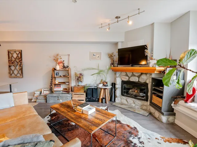 Living area featuring baseboards, a fireplace, track lighting, and wood finished floors