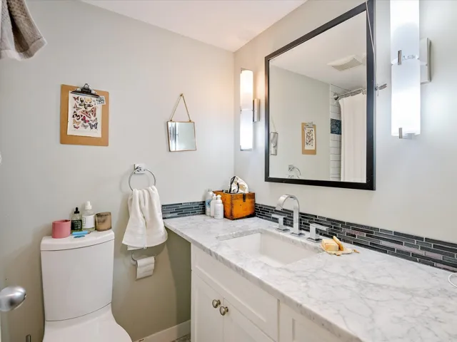 Bathroom featuring backsplash, visible vents, vanity, and toilet