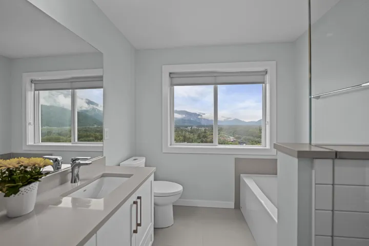 Bathroom with a mountain view, vanity, a bath, and light tile patterned floors
