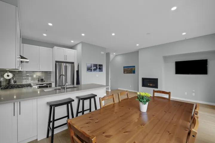 Dining area featuring light wood-style floors, a glass covered fireplace, and recessed lighting