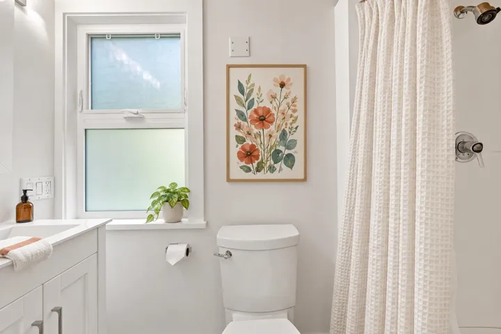 White bathroom vanity with shaker-style cabinetry and a single-handle faucet