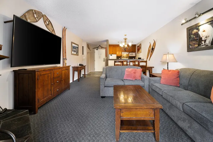 Living room featuring dark carpet and hanging lights