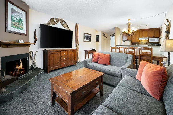 Carpeted living room with a chandelier, a tiled fireplace, and a textured ceiling