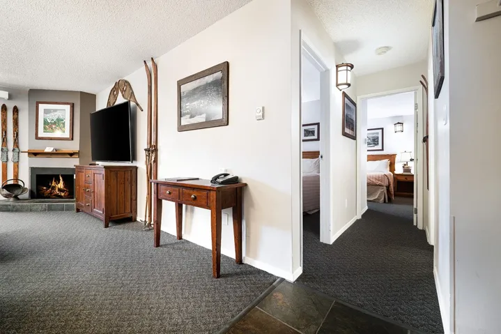 Hallway featuring dark colored carpet and a textured ceiling