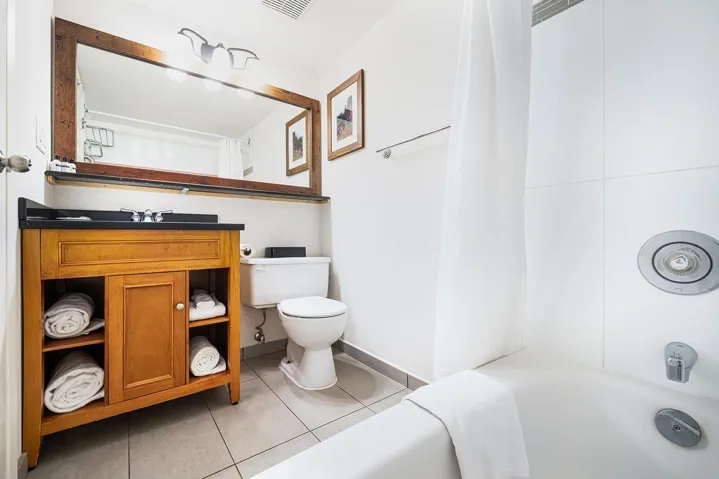 Full bath with vanity, light tile patterned floors, and shower / bath combo with shower curtain
