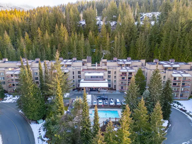 Snowy aerial view featuring a view of apartment building / complex
