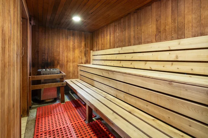 Relaxing sauna / steam room with wooden walls, wooden ceiling, and recessed lighting
