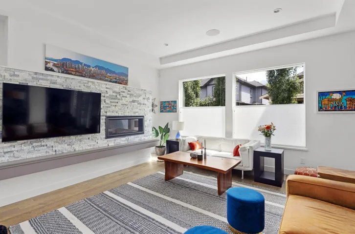 Living area featuring wood finished floors, a tray ceiling, and healthy amount of natural light