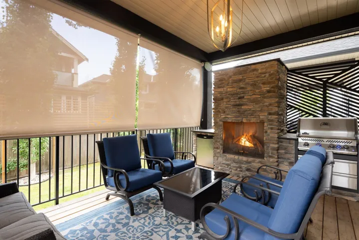 Wooden deck with an outdoor living space with a fireplace and area for grilling