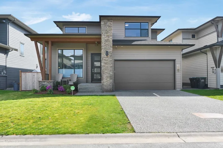 Prairie-style house featuring concrete driveway, an attached garage, and a front lawn