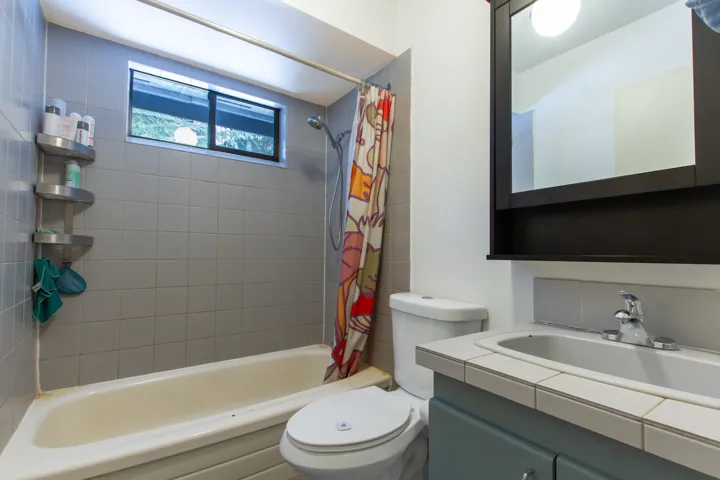 Full bathroom featuring vanity, shower / bath combination with curtain, and toilet