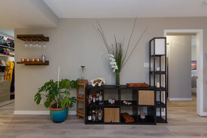 Interior details featuring baseboards, a bar, and wood finished floors