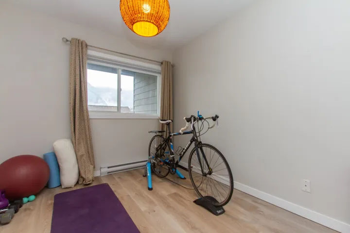 Workout room featuring wood finished floors, baseboards, and a baseboard radiator