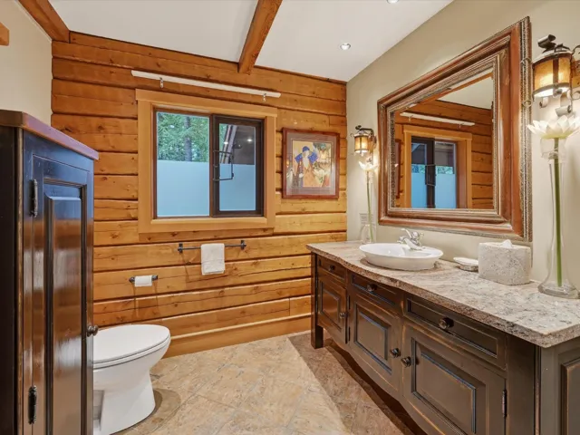 Bathroom featuring wood walls, vanity, and beam ceiling