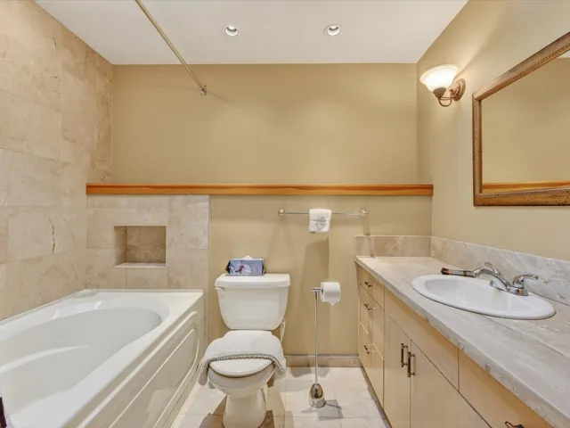 Bathroom featuring vanity, light tile patterned floors, shower / bathtub combination, and recessed lighting