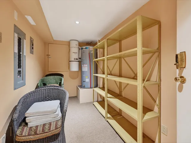 Storage area featuring water heater and electric panel