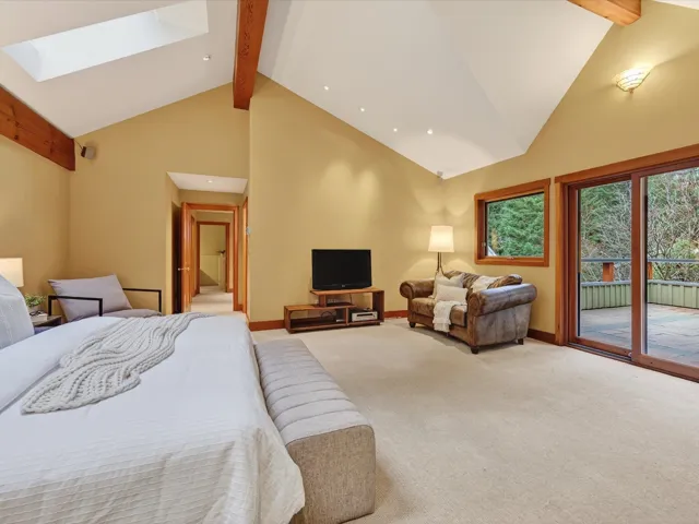 Carpeted bedroom with beam ceiling, high vaulted ceiling, a skylight, access to outside, and recessed lighting