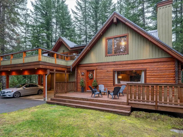 Back of property with a deck, log exterior, and a lawn