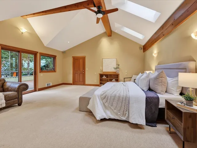 Bedroom with beam ceiling, access to outside, carpet flooring, ceiling fan, and a skylight