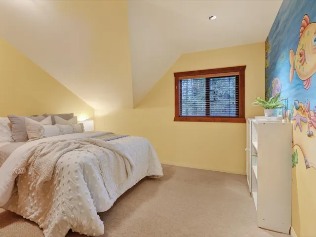 Bedroom featuring light colored carpet and vaulted ceiling