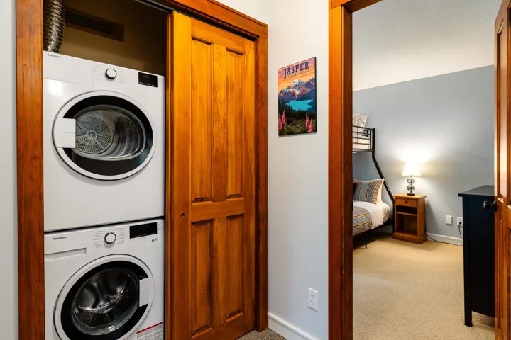 Laundry area with light carpet and stacked washer and clothes dryer
