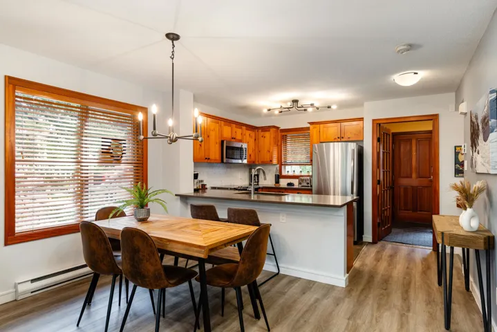 Dining room with light wood-style flooring, a chandelier, and a baseboard heating unit