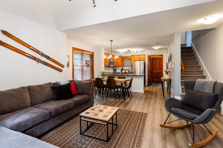 Living room with stairway, light wood-type flooring, and a chandelier