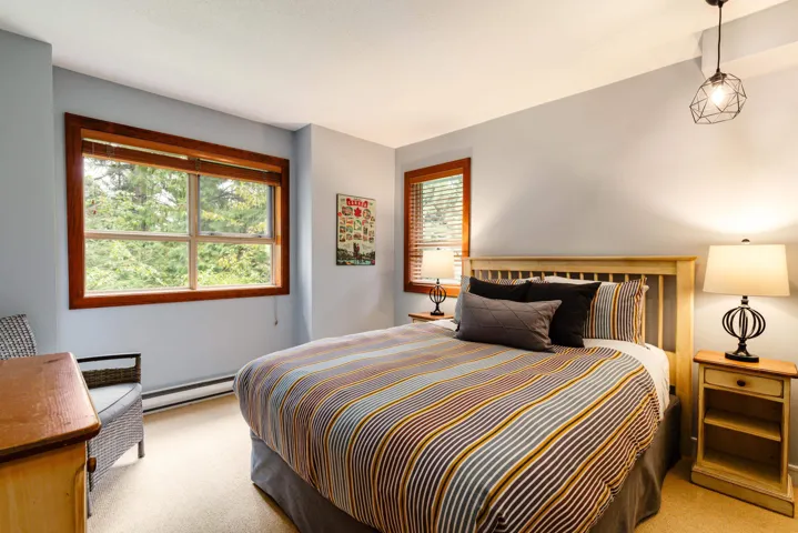 Bedroom featuring light carpet and a baseboard heating unit