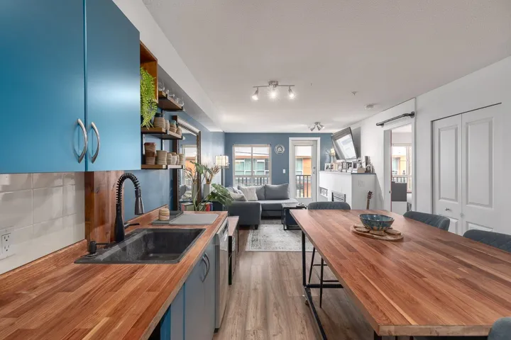 Kitchen featuring open shelves, blue cabinets, wood counters, and backsplash