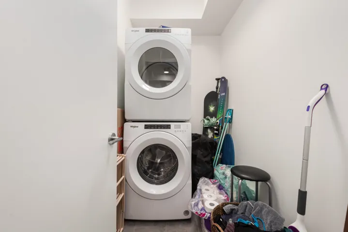 Dedicated laundry area featuring a stacked washer and dryer unit