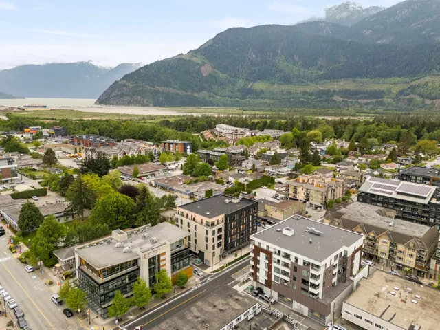 Aerial perspective showcasing a mixed-use urban area with a mountainous backdrop