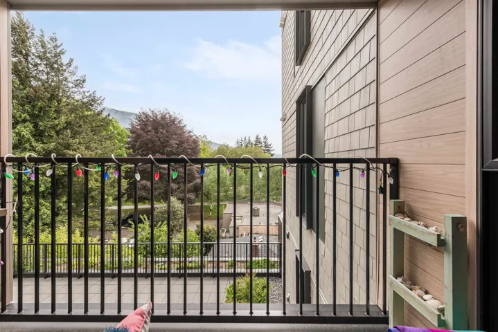 Exterior balcony featuring black metal railings and a textured concrete floor