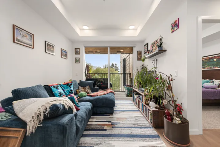 Living area featuring hardwood-finish flooring and a tray ceiling with recessed lighting