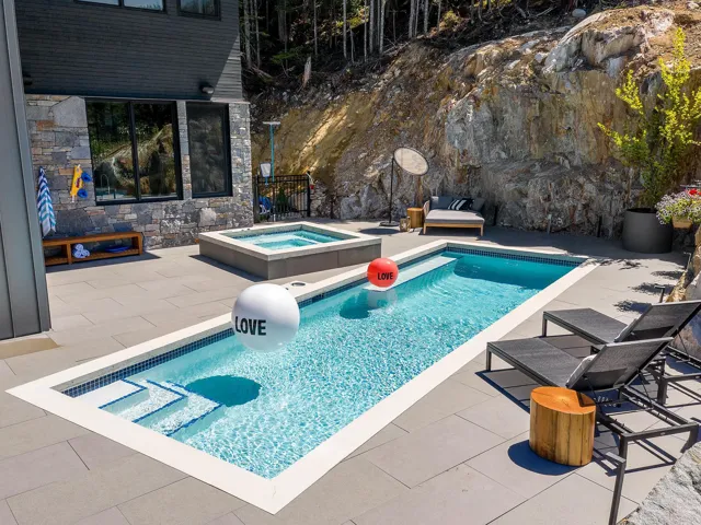 Outdoor pool with a patio and an in-ground hot tub